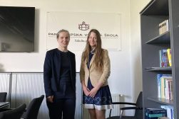 Dr Aleksandra Gawrysiak-Zabłocka na Wydziale Prawa Pan-European University (Paneurópska vysoká škola) w Bratysławie, pozuje do zdjęcia z badaczką z Bratysłąwy, na tle godła wydziału.