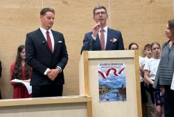 Prodziekan WPiA UKSW Dr. Zbigniew Więckowski przemawia z mównicy w auli podczas II Lekcji Śpiewania pieśni patriotyczych WPiA UKSW. W tle studencki chór.