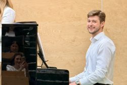 Pianista gra na fortepianie podczas koncertu pieśni patriotycznych w sali Wydziału Prawa i Administracji UKSW