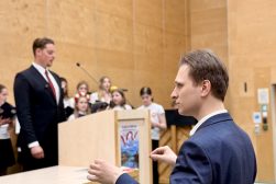 Dyrygent prowadzi chór podczas koncertu pieśni patriotycznych w sali Wydziału Prawa i Administracji UKSW