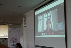 Uczestniczka Konferencji wygłaszajacy wykład za pośrednictwem wideo rozmowy podczas konferencji naukowej „Dziedzictwo Alfreda Ohanowicza”. Wideorozmowa wyświetlana na ekranie.