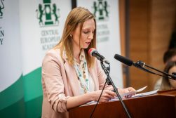 Joanna Kot odczytuje przygotowane wystąpienie przy mównicy, na tle baneru Central European Academy
