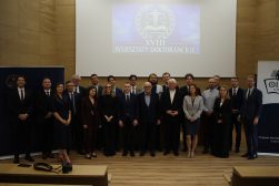 prof. Martyna Wilbrandt-Gotowicz wraz Uczestnikami XVIII Warsztatów Doktoranckich pozują do wspólnego zdjęcia w sali konferencyjnej. W tle widoczne logo Warsztatów.