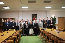 prof. Martyna Wilbrandt-Gotowicz wraz Uczestnikami spotkania naukowego pozują do wspólnego zdjęcia w sali konferencyjnej. W tle widoczny jest portret Mikołaja Kopernika