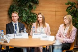 Dr Marcin Niedbała, Joanna Kot i Natalia Wałecka siedzą przy stole podczas spotkania; przed nimi stoją wizytówki i butelki z wodą.